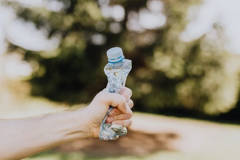 Botol plastik yang diremas oleh tangan